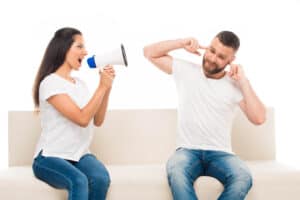 Woman yelling at man with a megaphone
